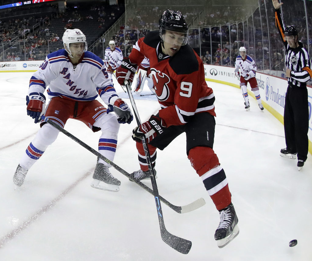In a photo taken Saturday, Oct. 1, 2016, New Jersey Devils left wing Taylor Hall, right, skates against New York Rangers' Philip McRae during the second period of an NHL hockey game in Newark, N.J. (AP Photo/Julio Cortez)