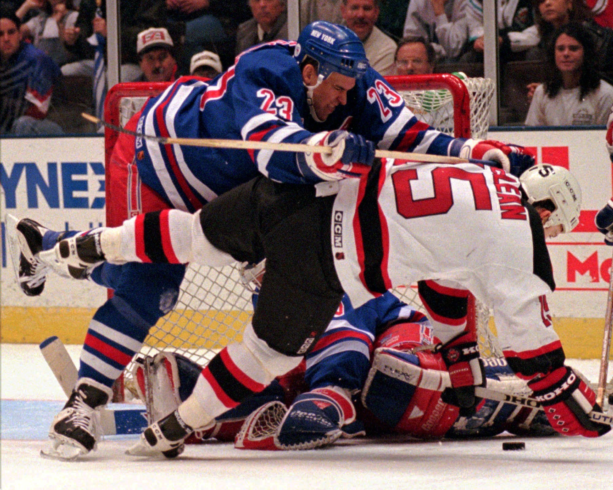 FILE--New Jersey Devils' John MacLean (15) is checked to the ice by New York Rangers' Jeff Beukeboom (23) as MacLean attempted to get his stick on the puck in front of Rangers goaltender Mike Richter, rear, in this April 7, 1996 photo, in East Rutherford, N.J. Beukeboom said Thursday he will be unable to resume his NHL career because of a series of concussions last season. (AP Photo/Bill Kostroun)