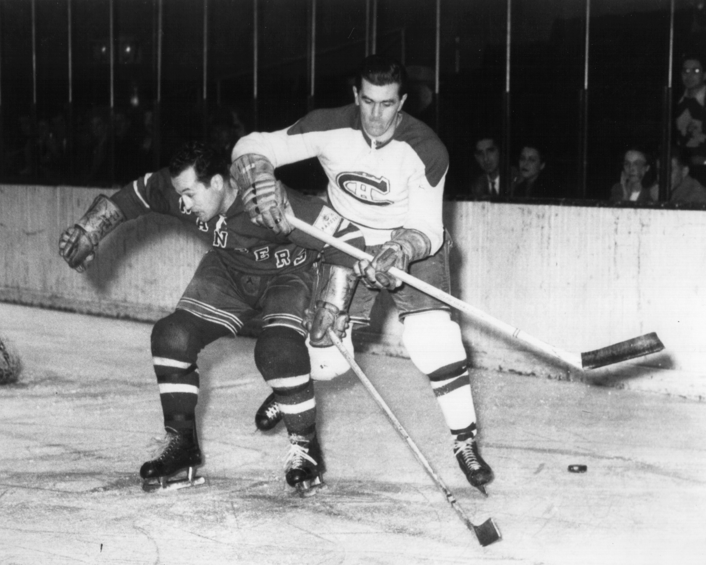 NEW YORK, NY - 1950: Maurice Richard #9 of the Montreal Canadiens battles with Edgar Laprade of the New York Rangers during an NHL game circa 1950 at Madison Square Garden in New York, New York. (Photo by Bruce Bennett Studios/Getty Images)