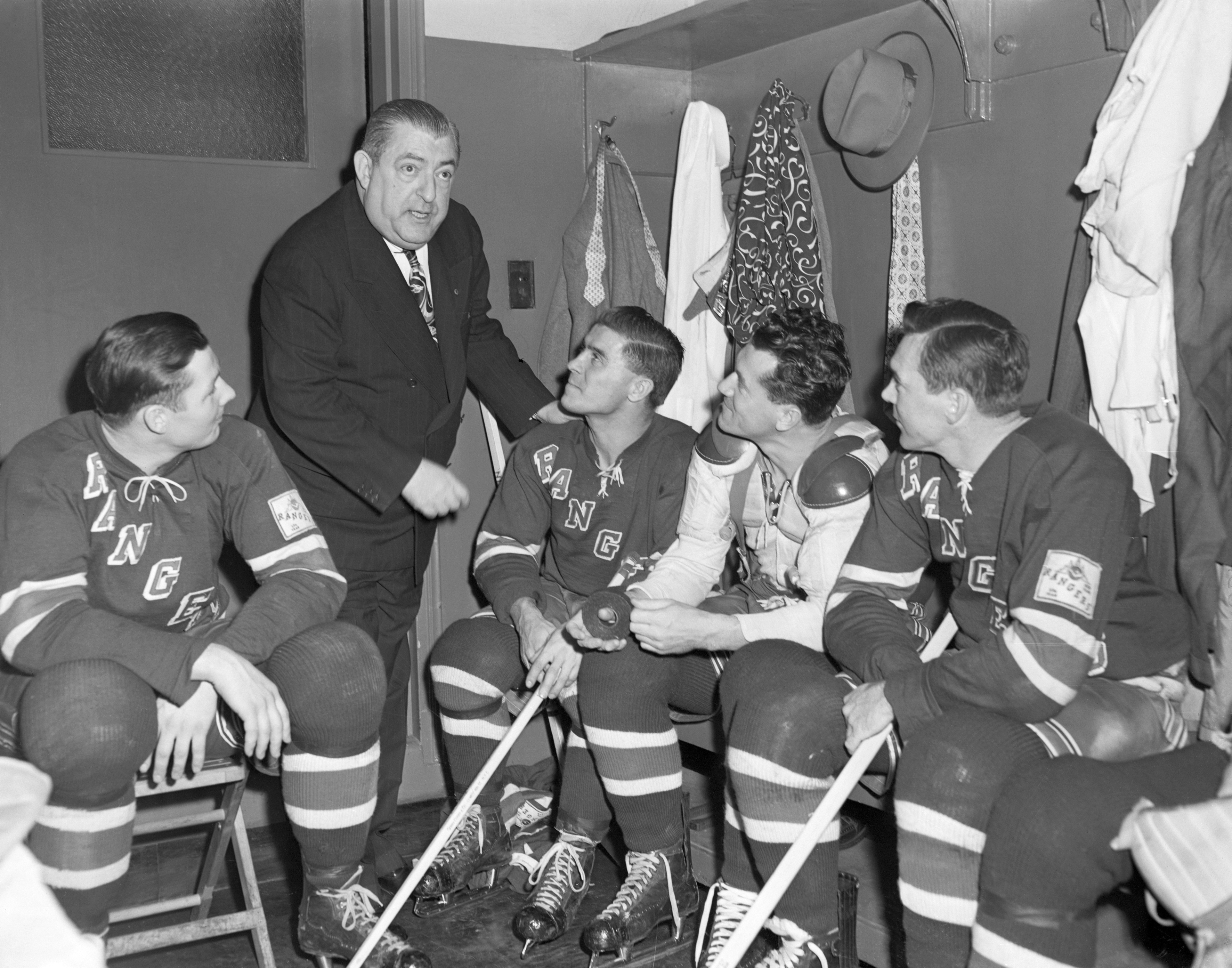 11/15/1950 - New York, NY - Dr. David F. Tracy (second from left) talks to some Rangers before a tilt with Nov. 15th bout. From left to right are Rangers: Pentti Lund; Tony Leswick; Killer Kaleta and Buddy O'Connor (Photo Courtesy of Getty Images).
